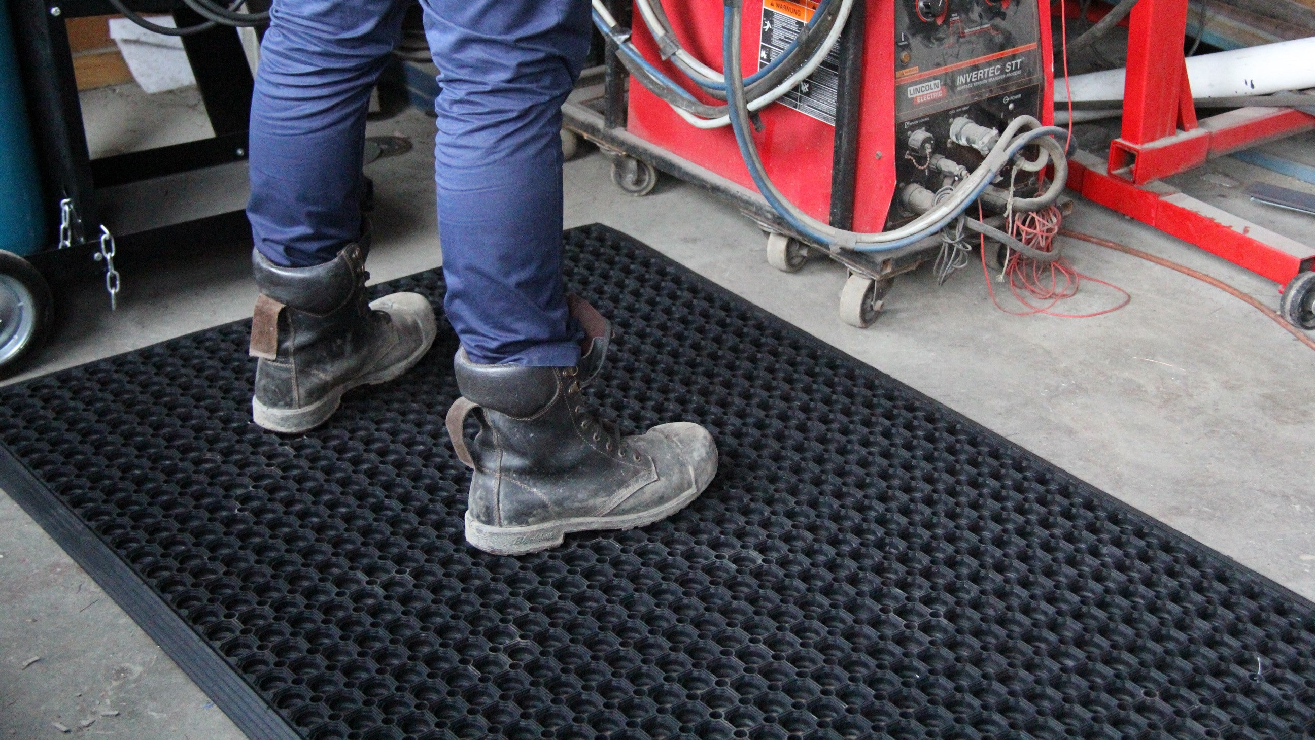 man wearing boots stepping on a floor matting